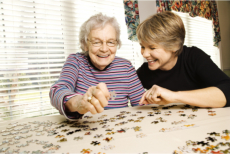 A caregiver and an elderly playing a puzzle game