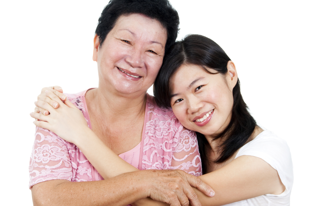 Asian caregiver hugging an elderly